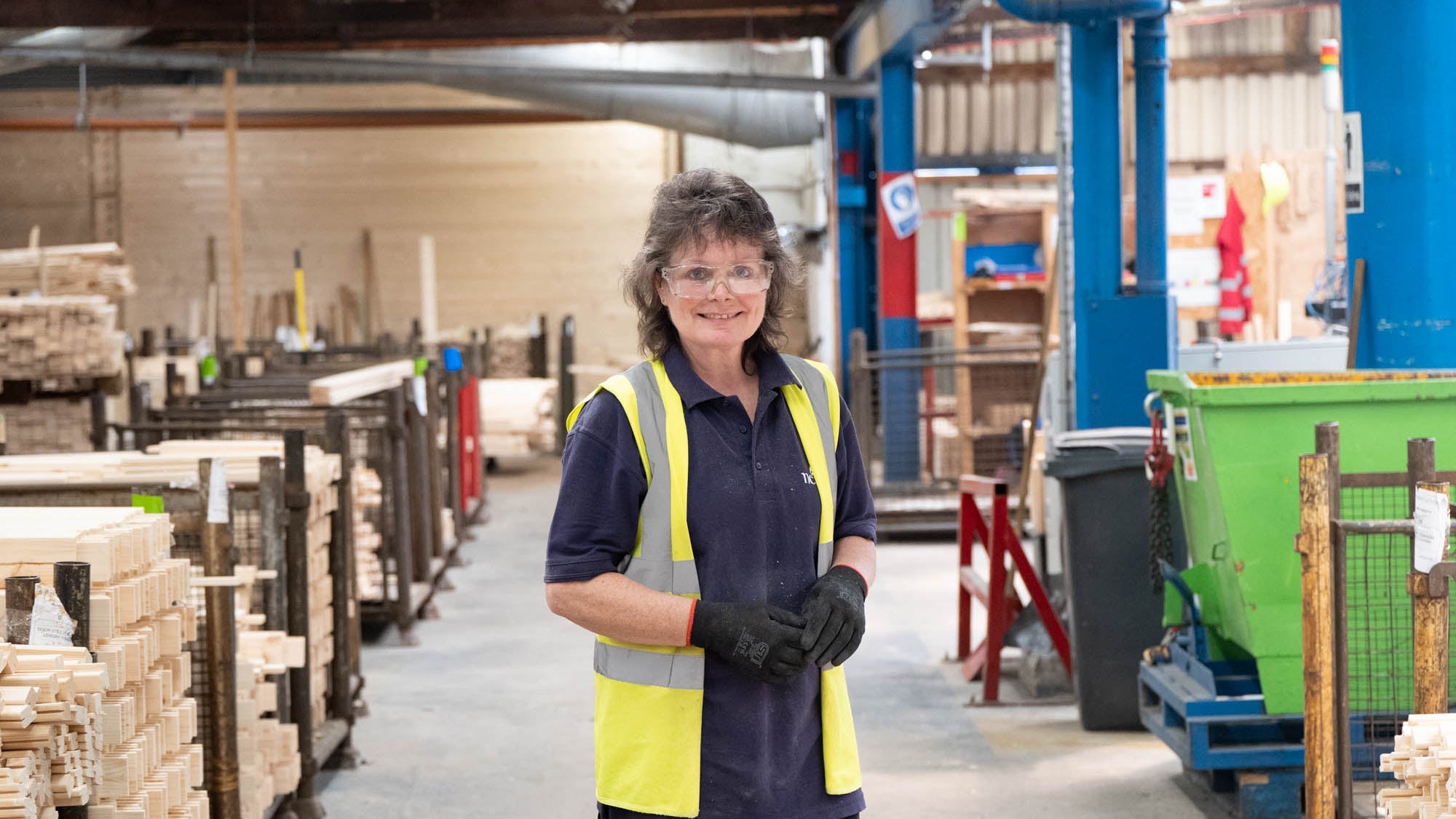 Person wearing a high-visibility vest in a warehouse setting